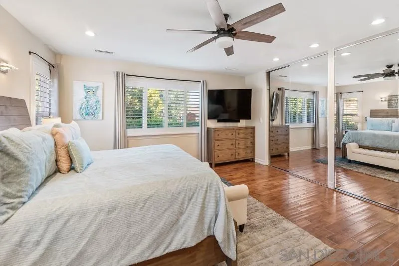 12750 McFeron Road Poway, CA 92064 - Photo 8 of 51 a spacious bedroom with a large bed a flat tv screen and a chandelier