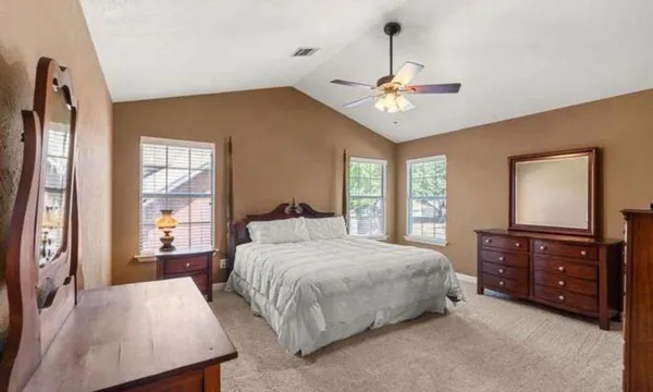 a bedroom with a bed dresser and a window