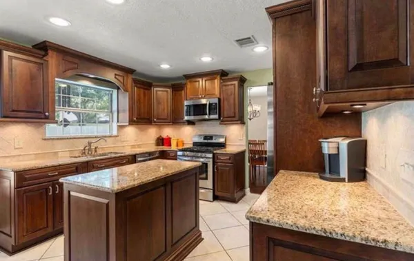 a kitchen with stainless steel appliances granite countertop sink stove top oven and microwave