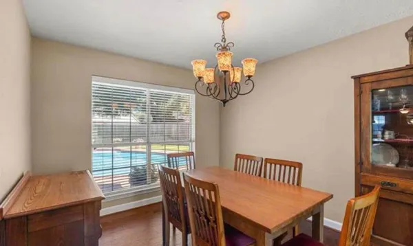 a view of a dining room with furniture wooden floor and chandelier