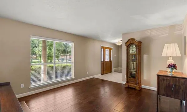 wooden floor in an empty room with a window