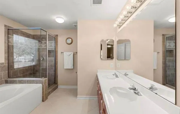a bathroom with a tub sink and mirror