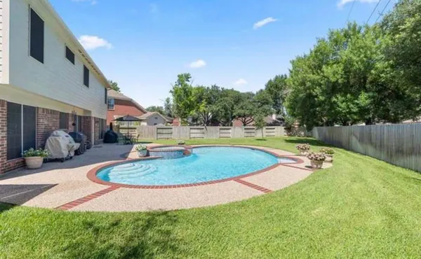 a view of a swimming pool with a yard and sitting space