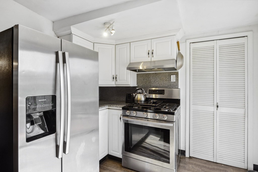 20 13th Street Wareham, MA 02558 - Photo 13 of 30 a kitchen with stainless steel appliances a refrigerator a stove and white cabinets