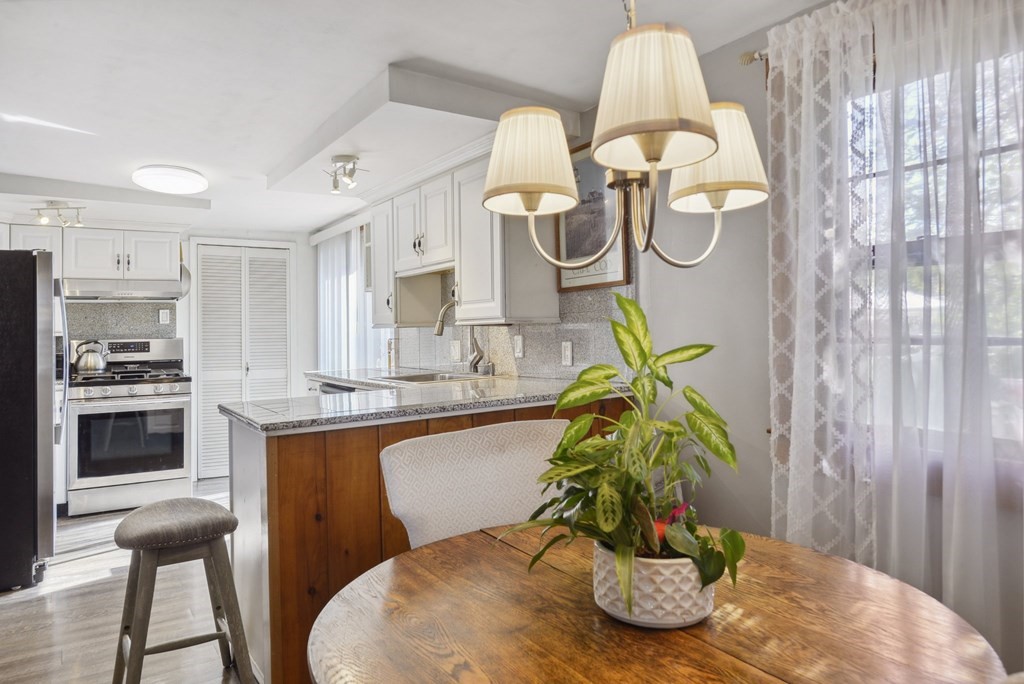 20 13th Street Wareham, MA 02558 - Photo 16 of 30 a dining room with kitchen island stainless steel appliances furniture wooden floor and view kitchen