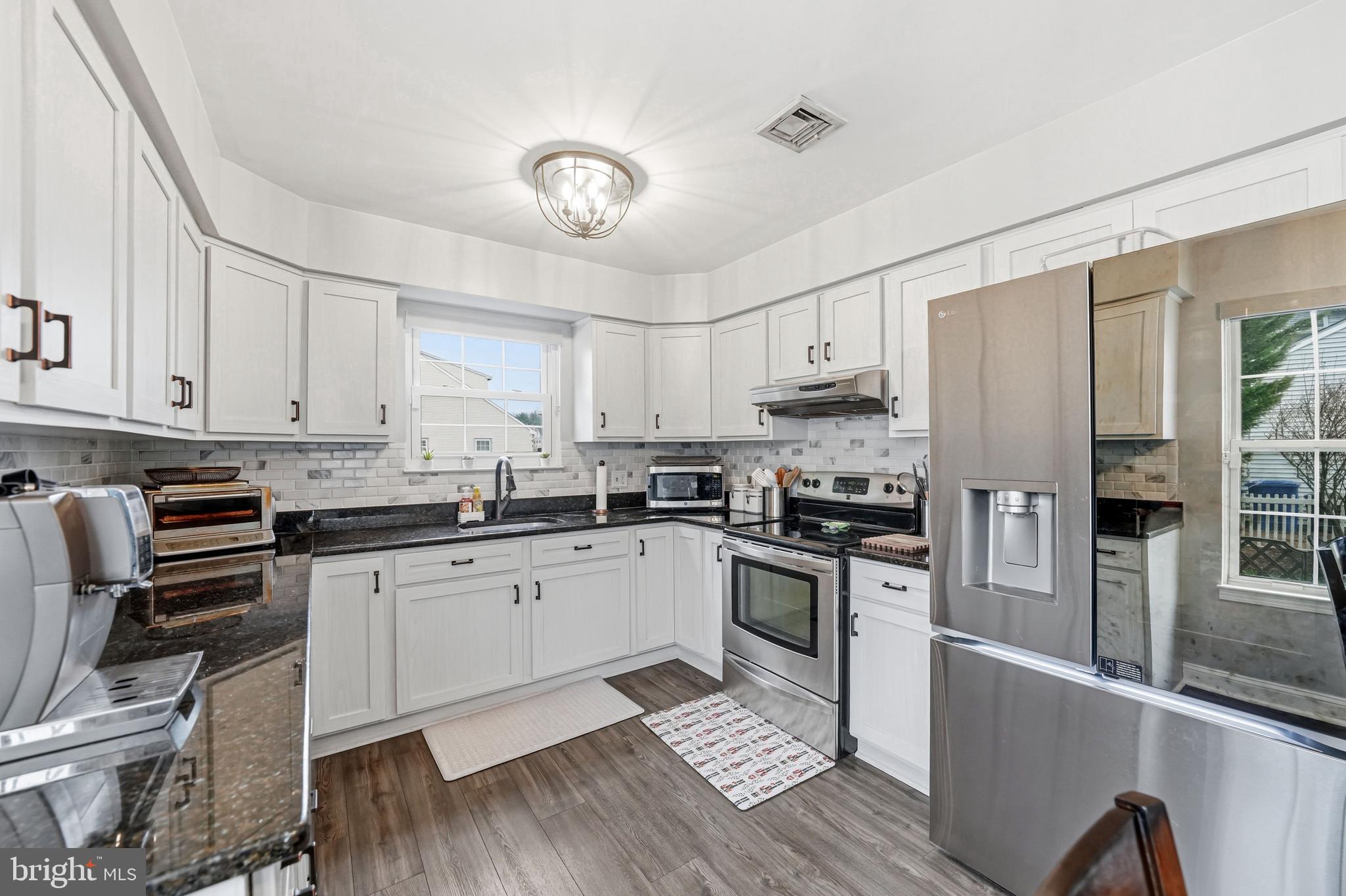 7 Watson Drive Mount Laurel, NJ 08054 - Photo 20 of 42 a kitchen with stainless steel appliances granite countertop a stove top oven a refrigerator a sink and dishwasher a oven with wooden floor