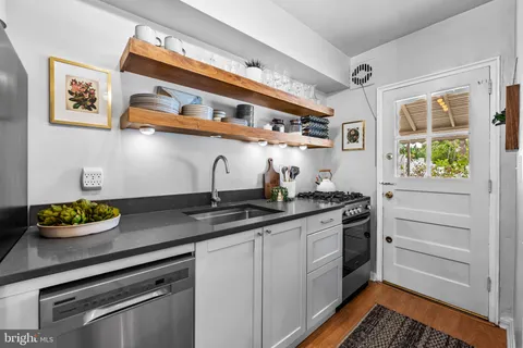 a kitchen with stainless steel appliances granite countertop a sink stove and cabinets