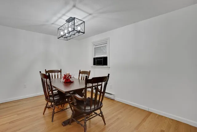 a view of a dining room with furniture a chandelier and wooden floor