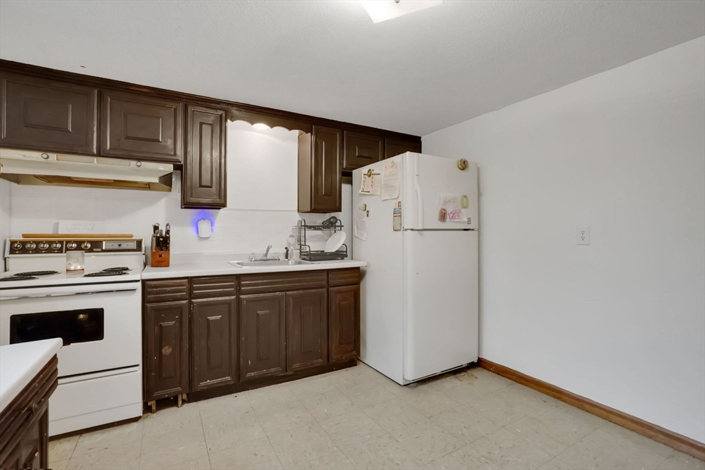 290 Newton Road Springfield, MA 01118 - Photo 23 of 38 a kitchen with a refrigerator sink and cabinets
