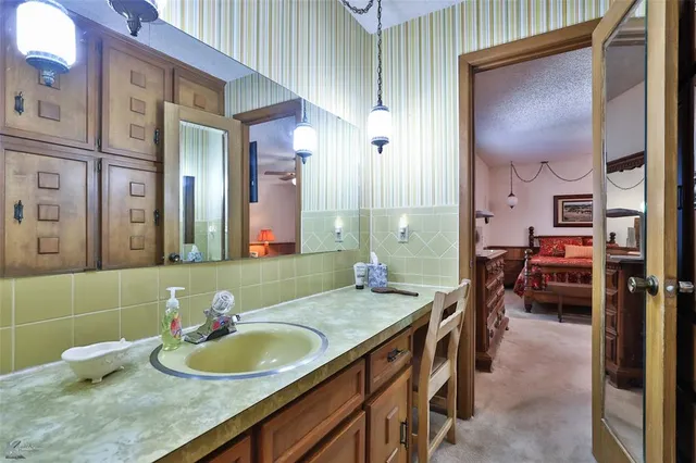 a bathroom with a tub sink and mirror