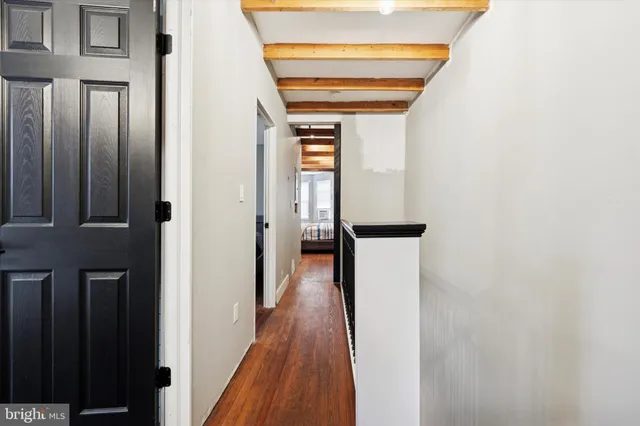 a view of a hallway with wooden floor and staircase