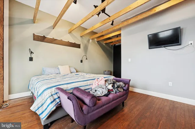 a bedroom with a bed window and a flat screen tv