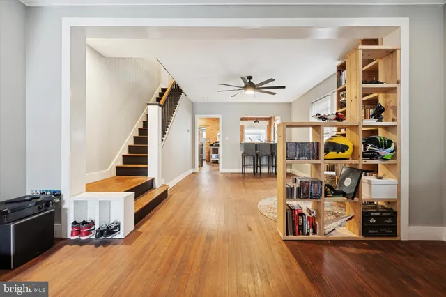 a view of a living room with wooden floor and stairs