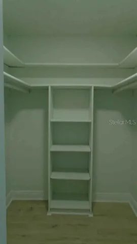a view of walk in closet with empty racks