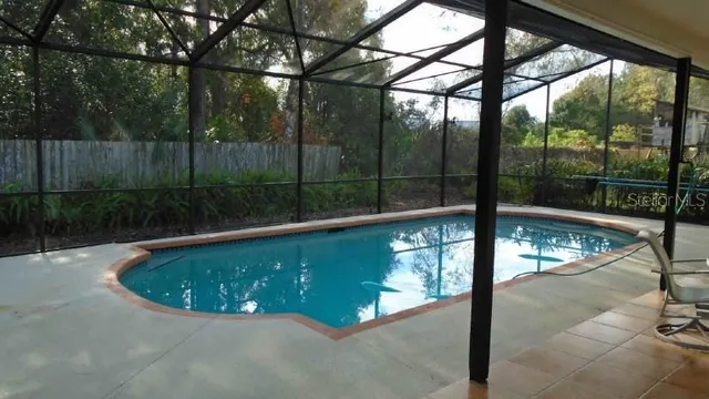 a swimming pool with outdoor seating and yard