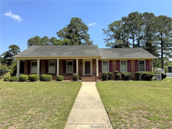 a front view of a house with yard and green space