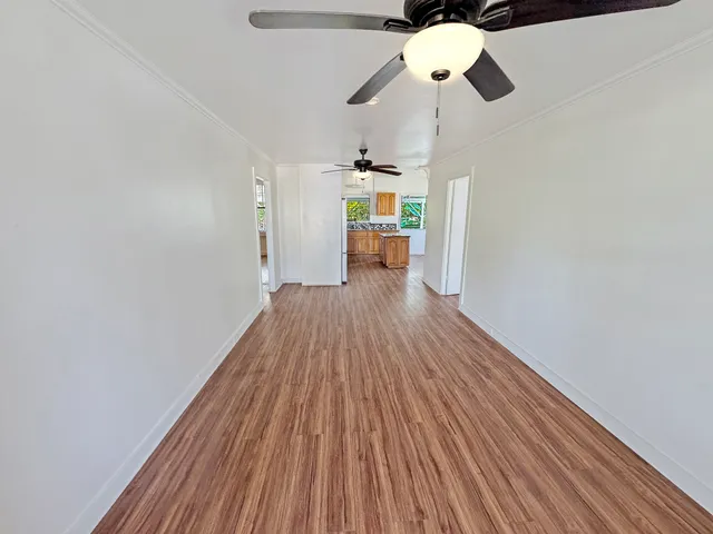 a view of a room with wooden floor ceiling fan