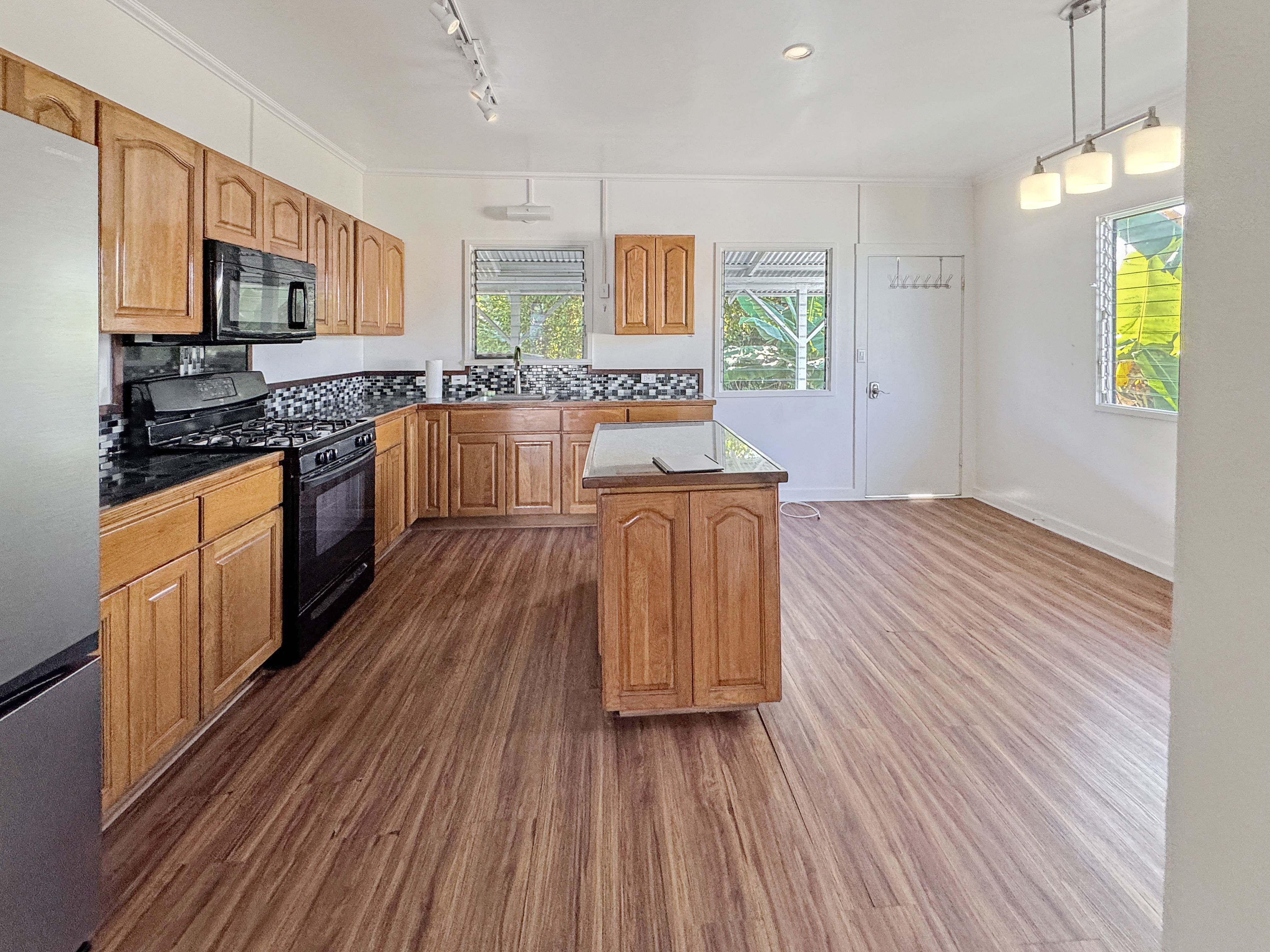 136 Mauna Loa Street Hilo, HI 96720 - Photo 4 of 23 a kitchen with stainless steel appliances wooden floors and wooden cabinets