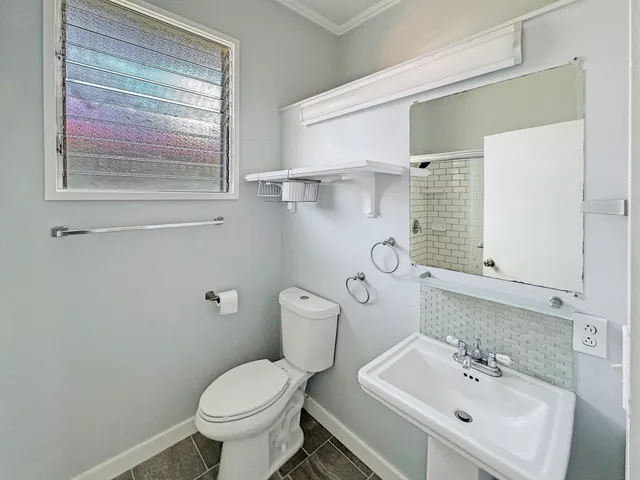 a bathroom with a toilet sink and mirror
