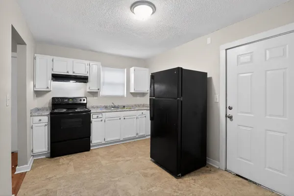 a kitchen with a refrigerator and a stove