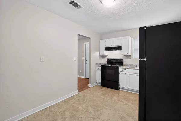 a kitchen with a refrigerator and a stove