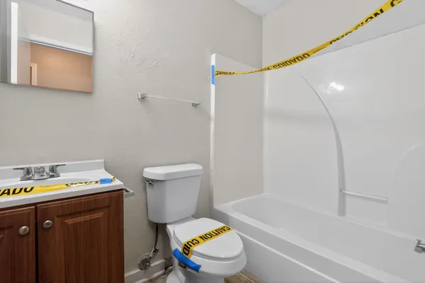 a bathroom with a bath tub sink mirror vanity and toilet