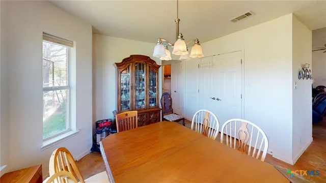 a spacious bedroom with a bed and a flat tv screen on dresser