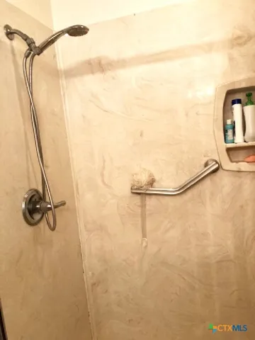 a bathroom with a granite countertop shower