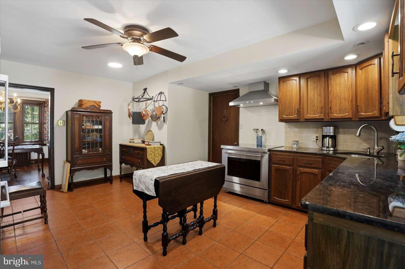 273 Strafford Avenue Wayne, PA 19087 - Photo 13 of 42 a kitchen with stainless steel appliances granite countertop a stove top oven a sink a dining table and chairs with wooden floor