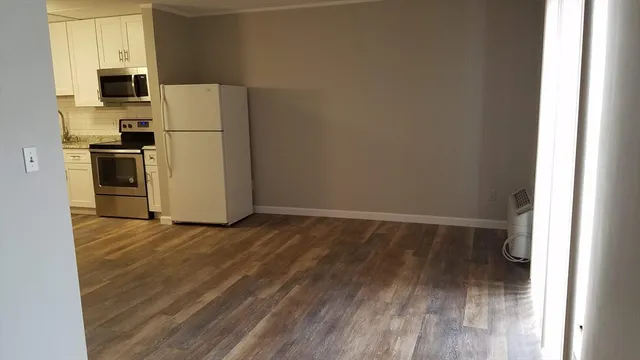 a view of a kitchen with a refrigerator a microwave and a window