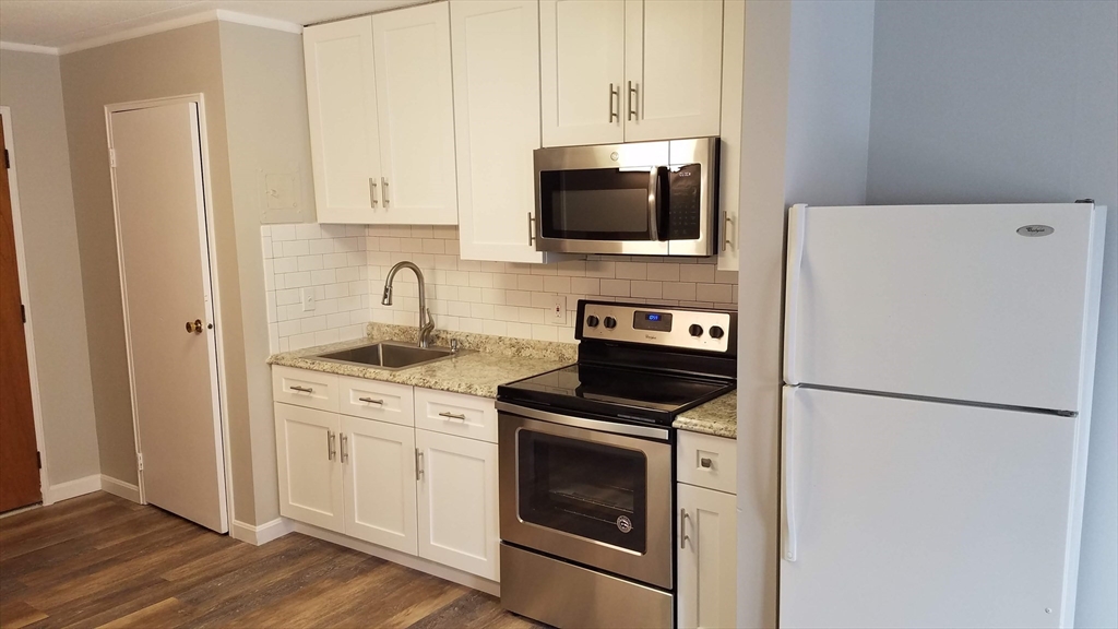 40 Cochituate Road, Unit 40 Framingham, MA 01701 - Photo 4 of 12 a kitchen with stainless steel appliances a refrigerator stove and microwave