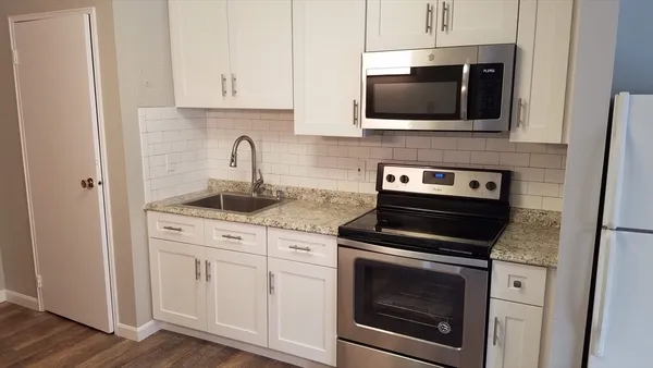 a kitchen with stainless steel appliances granite countertop a stove and a microwave