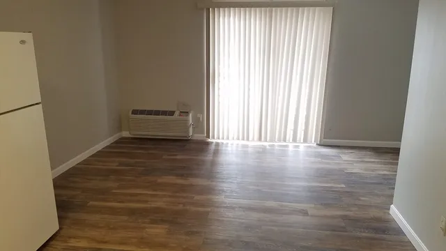 a view of a room with wooden floor and a window