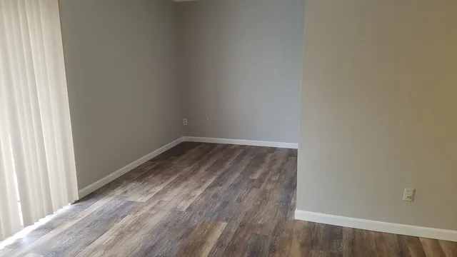 a view of a small space with wooden floor and a window