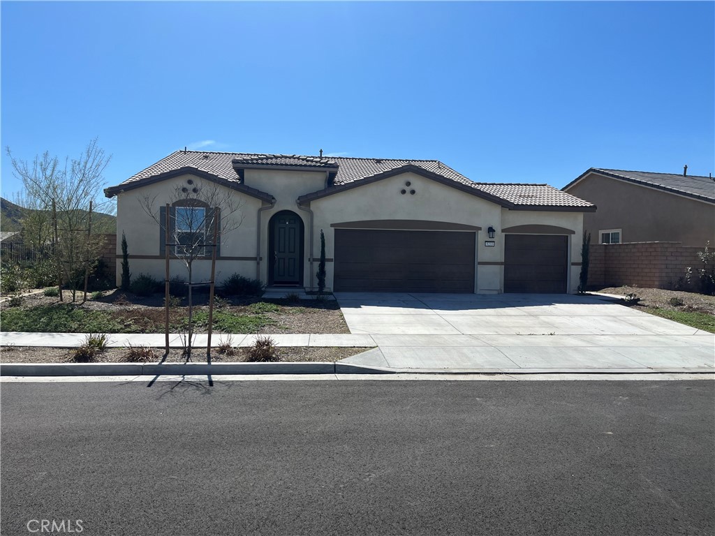 a front view of a house with a garden and yard