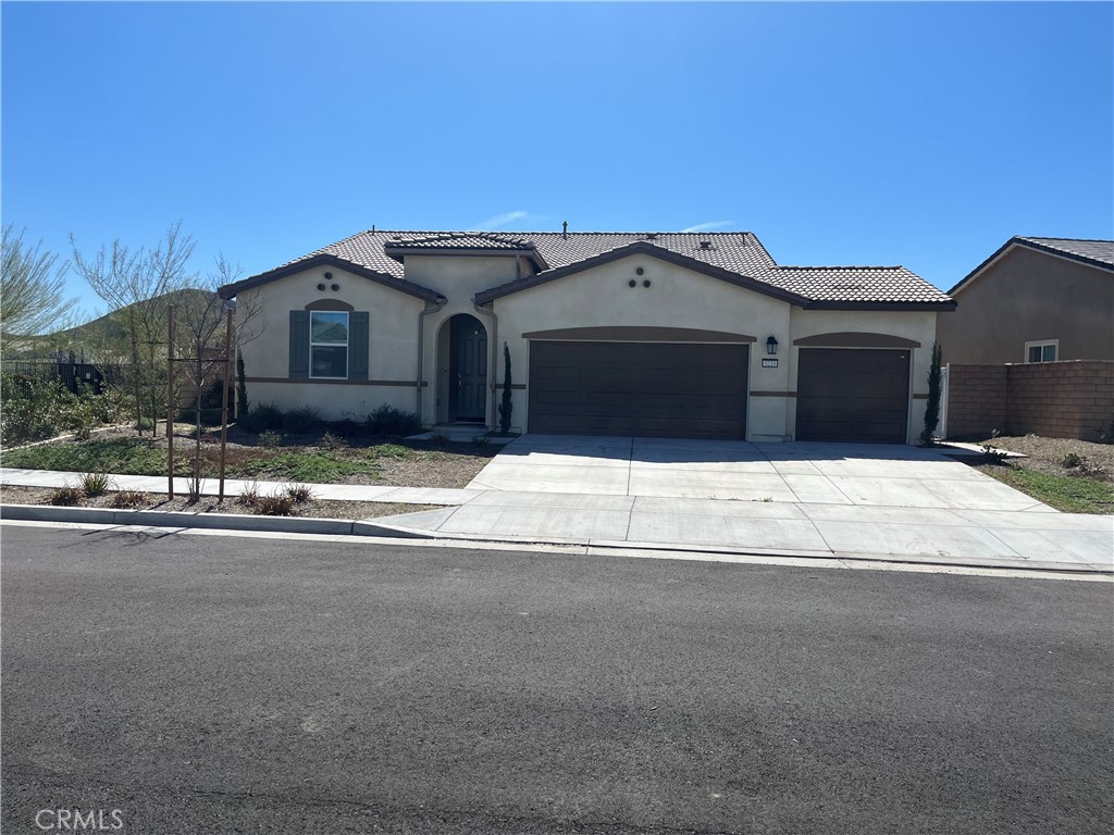 5233 Saloon Street Hemet, CA 92545 - Photo 2 of 18 a front view of a house with a yard and a garage