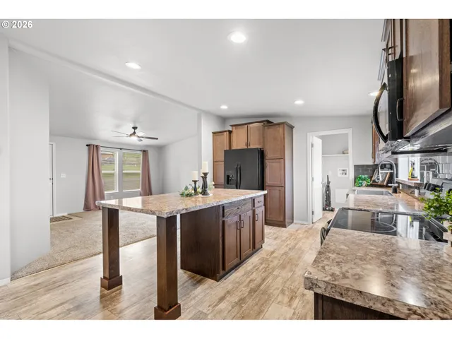 a living room with stainless steel appliances kitchen island granite countertop furniture and a kitchen view