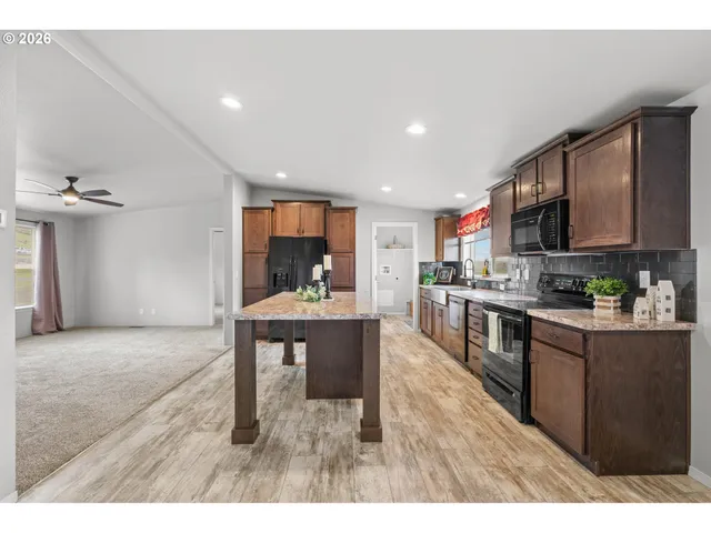 a kitchen with stainless steel appliances granite countertop a sink refrigerator and cabinets