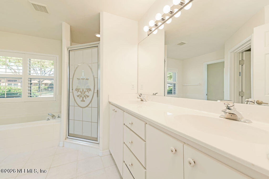 8 Peruvian Lane Ormond Beach, FL 32174 - Photo 12 of 40 a bathroom with a sink a mirror and a shower