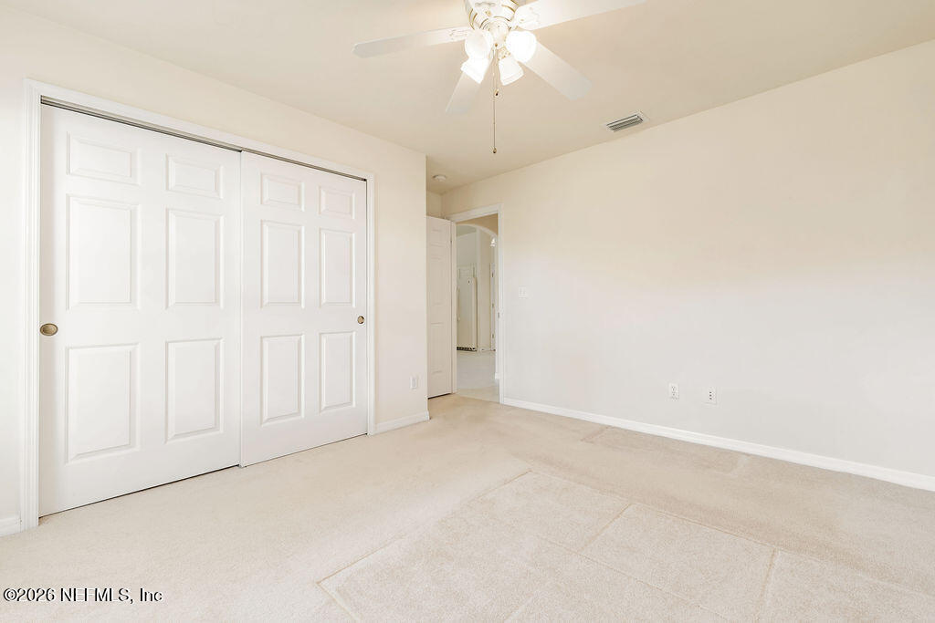 8 Peruvian Lane Ormond Beach, FL 32174 - Photo 19 of 40 an empty room with a ceiling fan and a window
