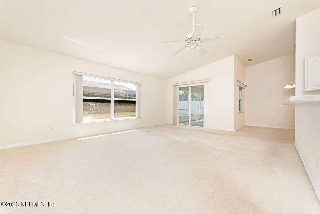 8 Peruvian Lane Ormond Beach, FL 32174 - Photo 23 of 40 an empty room with windows and chandelier fan