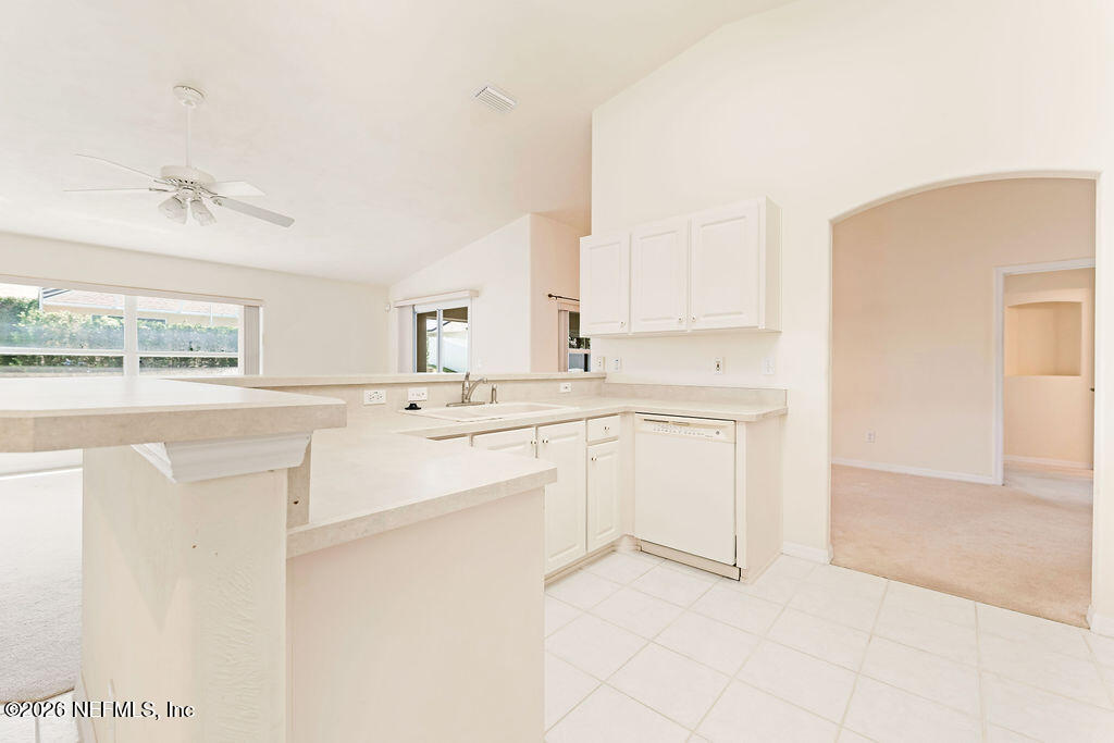 8 Peruvian Lane Ormond Beach, FL 32174 - Photo 7 of 40 a kitchen with white cabinets and white appliances
