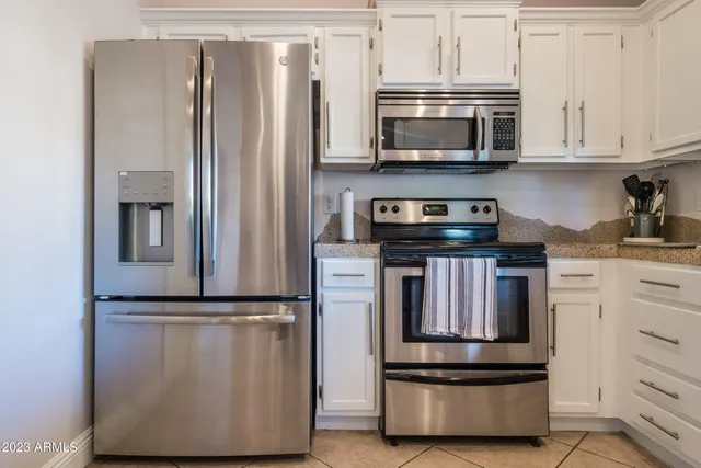 a kitchen with stainless steel appliances granite countertop a refrigerator stove and microwave