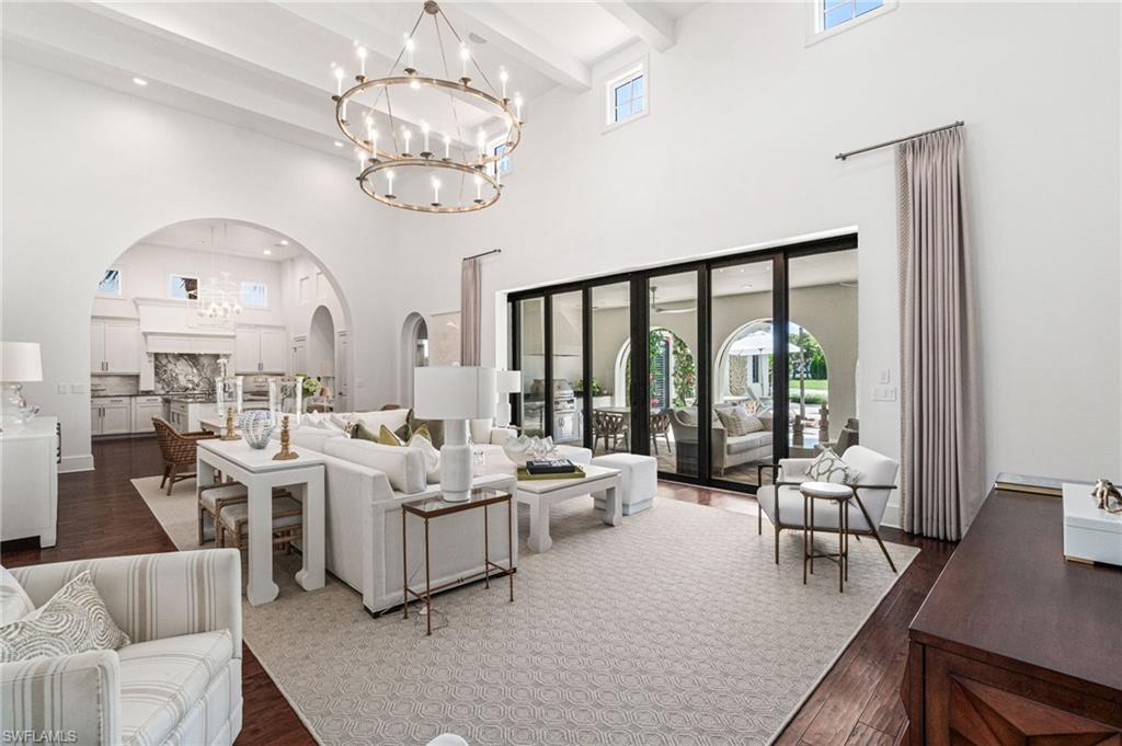 16755 Lucarno Way Naples, FL 34110 - Photo 3 of 50 a living room with furniture chandelier and large windows
