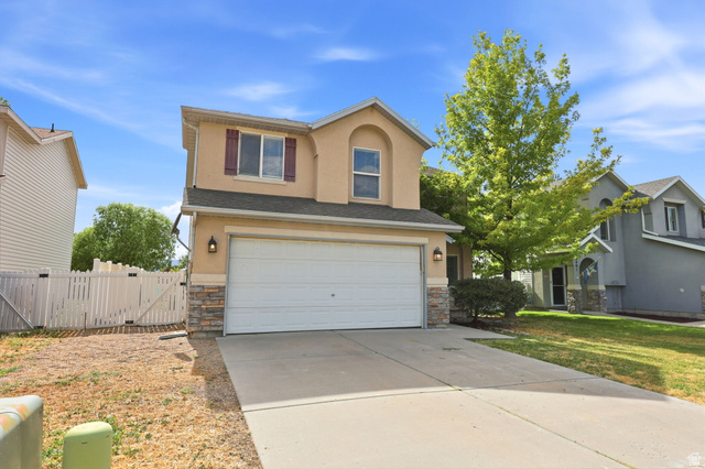 5485 Heather Way Tooele, UT 84074 - Photo 13 of 41 Two-story stucco exterior featuring a two-car garage, stone veneer accents, and a concrete driveway