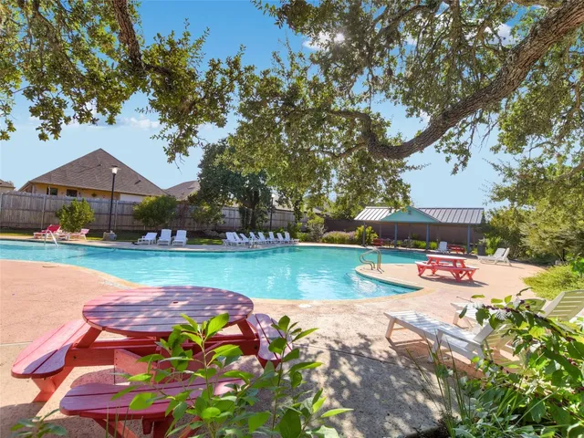 a view of a swimming pool with a garden and seating area