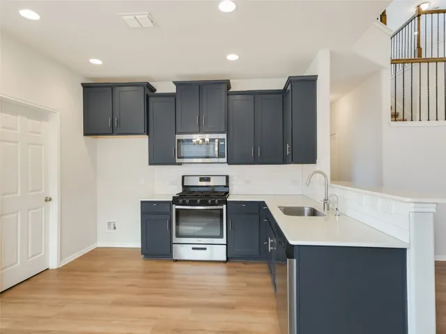 a kitchen with wooden cabinets and stainless steel appliances