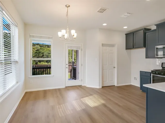 a view of a kitchen with wooden floor and a window