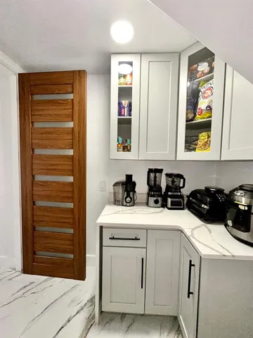 a living room with furniture a flat screen tv and white walls