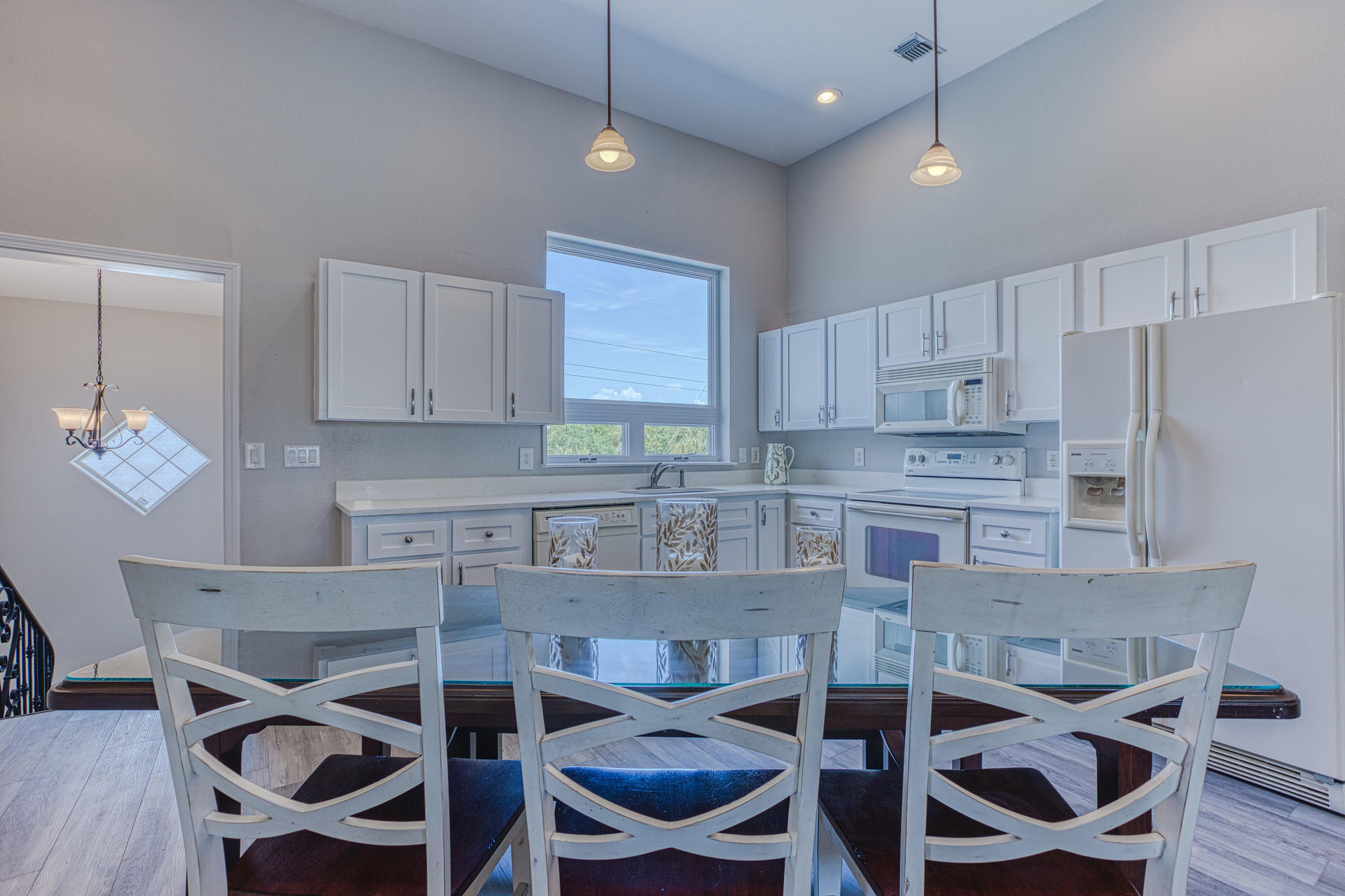 4583 Luke Avenue Destin, FL 32541 - Photo 31 of 86 a kitchen with a dining table chairs stainless steel appliances and cabinets